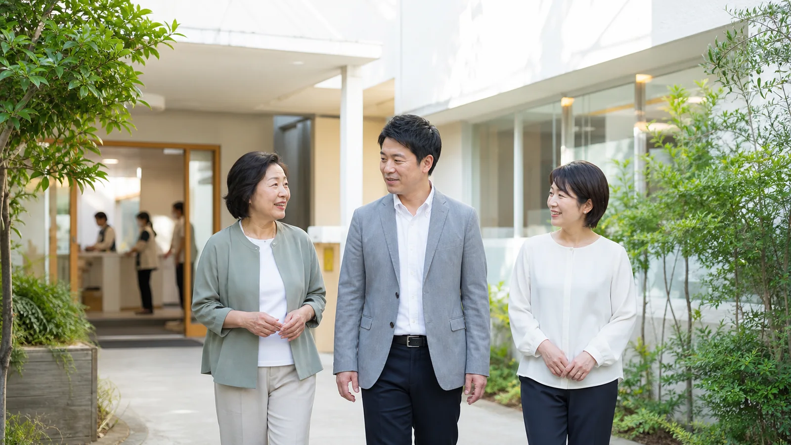 建物の中庭を歩きながら話す3人の説明用イメージ
